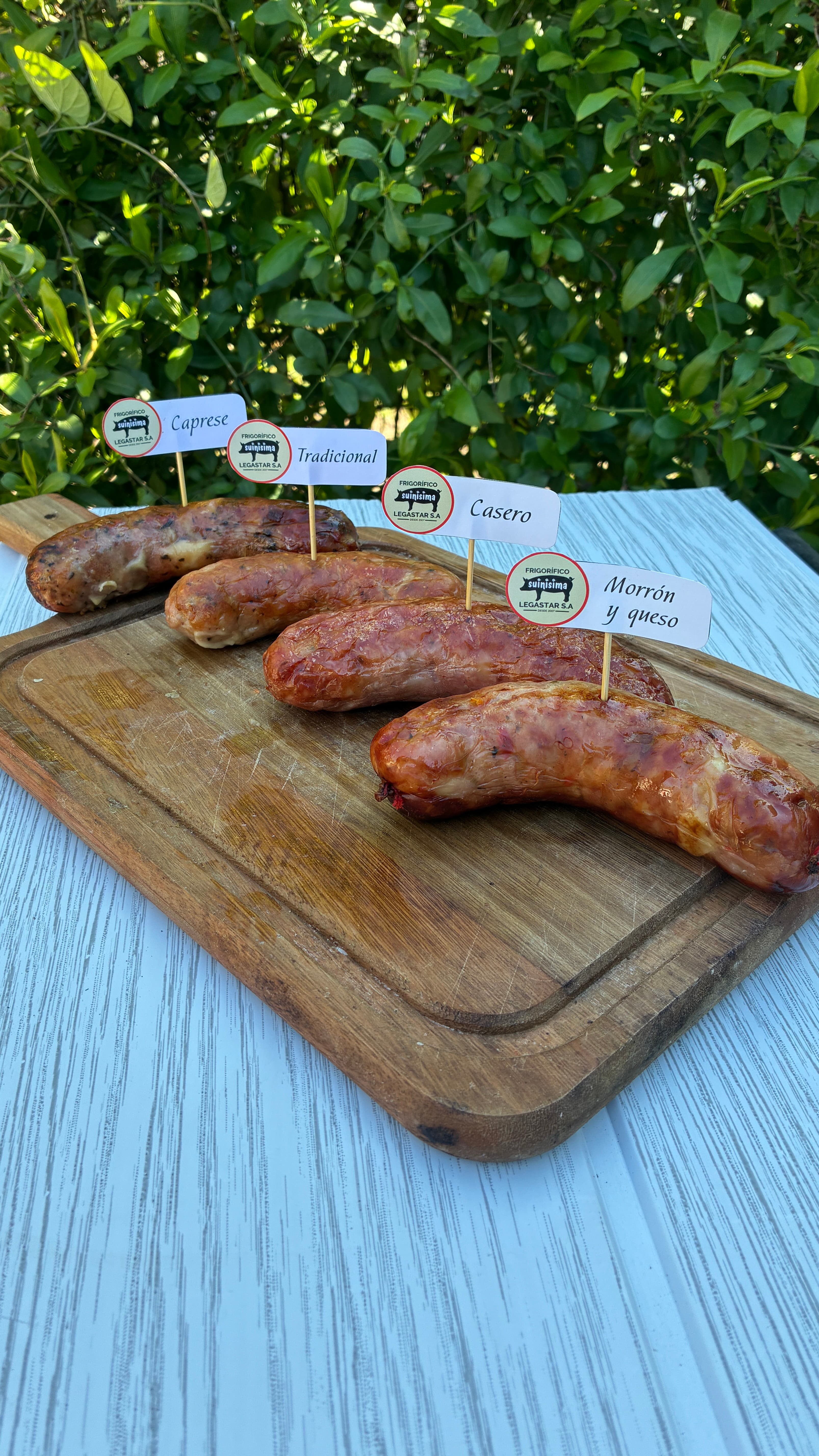 Variedades de chorizos artesanales (Caprese, Tradicional, Casero, Morrón y queso) sobre tabla — Legastar